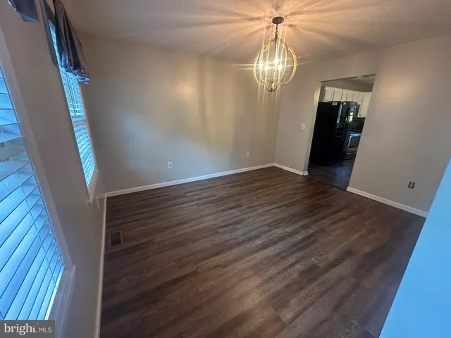 a view of empty room with window and ceiling fan