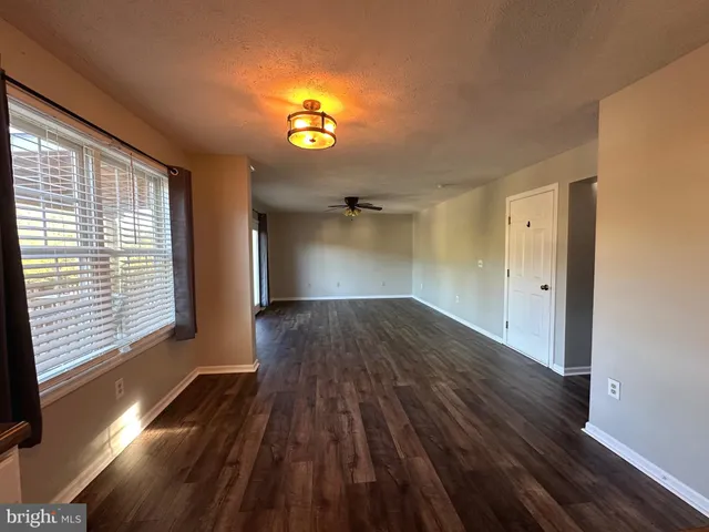 a kitchen with stainless steel appliances granite countertop a stove top oven a refrigerator a sink and a dining table with wooden floors