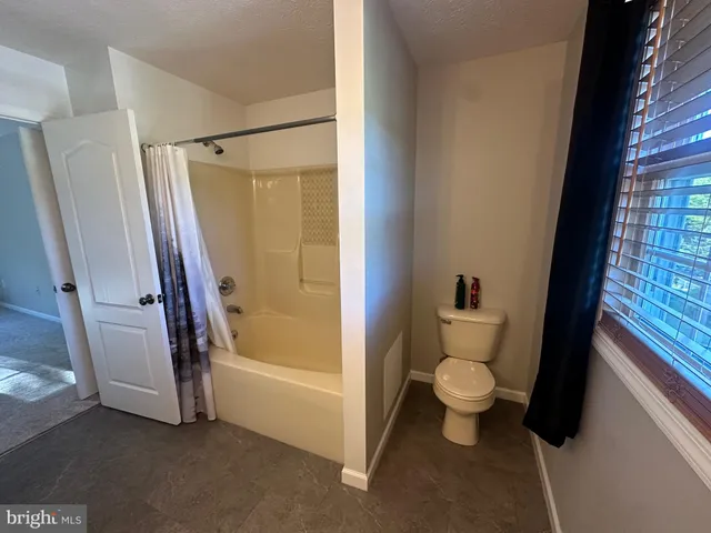 en empty room with windows and fan