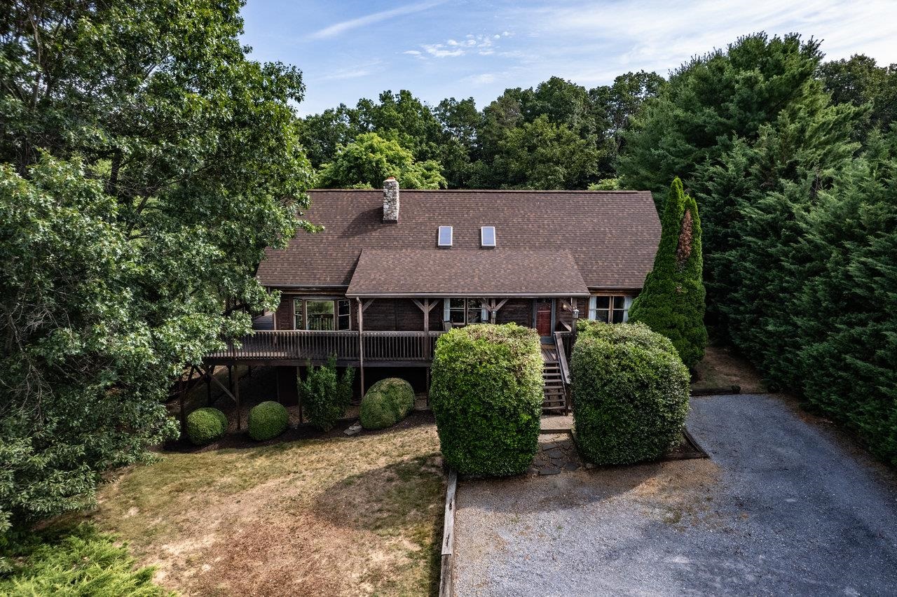 an aerial view of a house with garden space and a tree