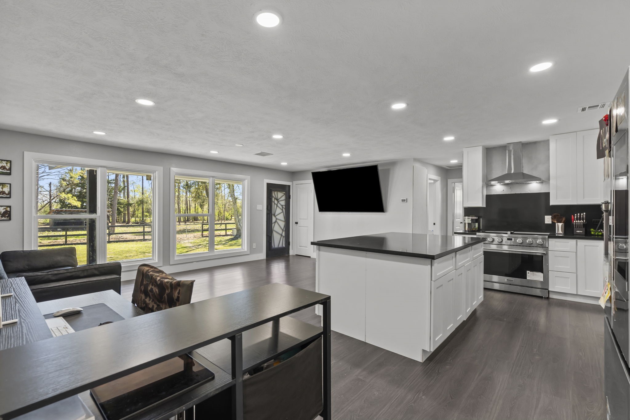 5406 South Tower Road Santa Fe, TX 77517 - Photo 13 of 46 a kitchen with stainless steel appliances granite countertop a stove top oven a sink dishwasher a dining table and chairs with wooden floor