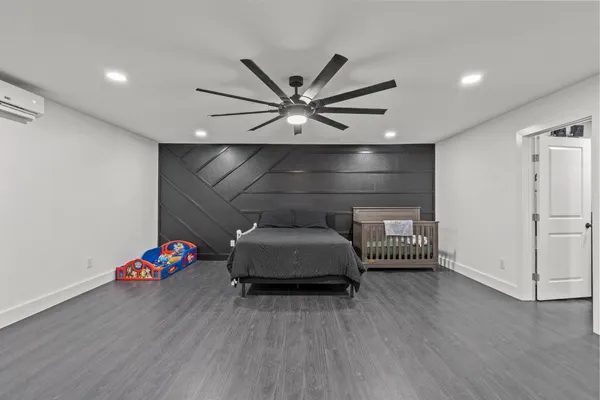 an empty room with wooden floor and ceiling fan