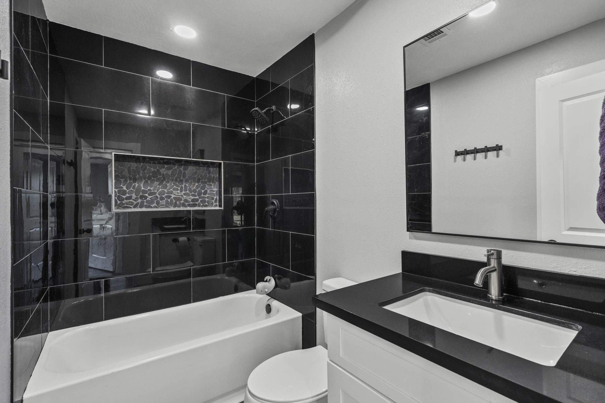 5406 South Tower Road Santa Fe, TX 77517 - Photo 32 of 46 a bathroom with a granite countertop sink a toilet a mirror and bathtub