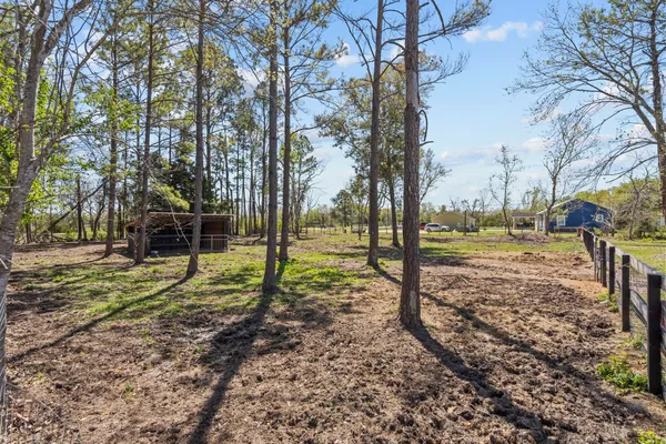 a view of a house with a yard and wooden fence