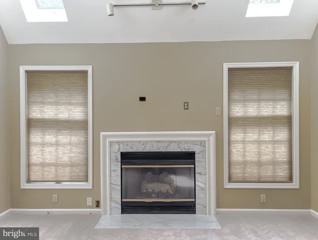 a living room with a fireplace and windows