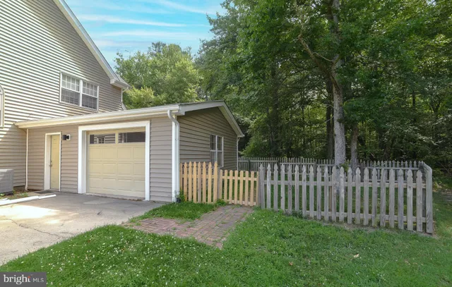 a view of a house with a small yard and wooden fence