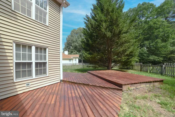 a view of a backyard with wooden floor and fence