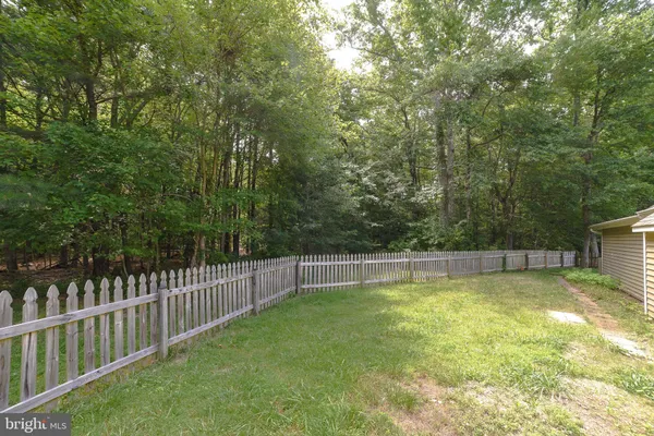 a view of a swimming pool with a small yard and large trees