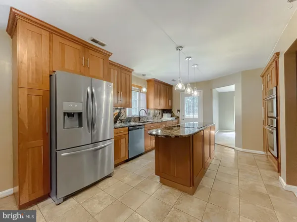a kitchen with granite countertop a refrigerator and a sink