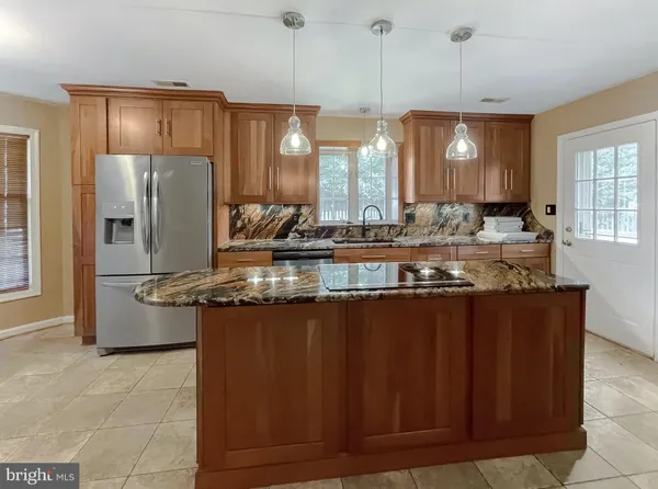 a kitchen with stainless steel appliances granite countertop a sink a stove and a refrigerator