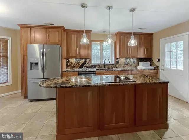 a kitchen with stainless steel appliances granite countertop a sink a stove and a refrigerator