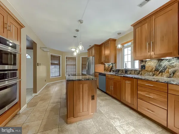 a open kitchen with kitchen island granite countertop a refrigerator oven stove a sink and dishwasher