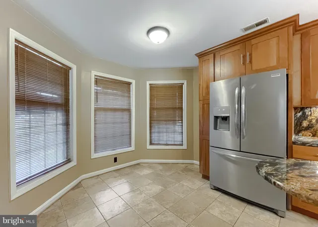 a view of a refrigerator in kitchen and windows