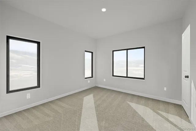 an empty room with windows and closet