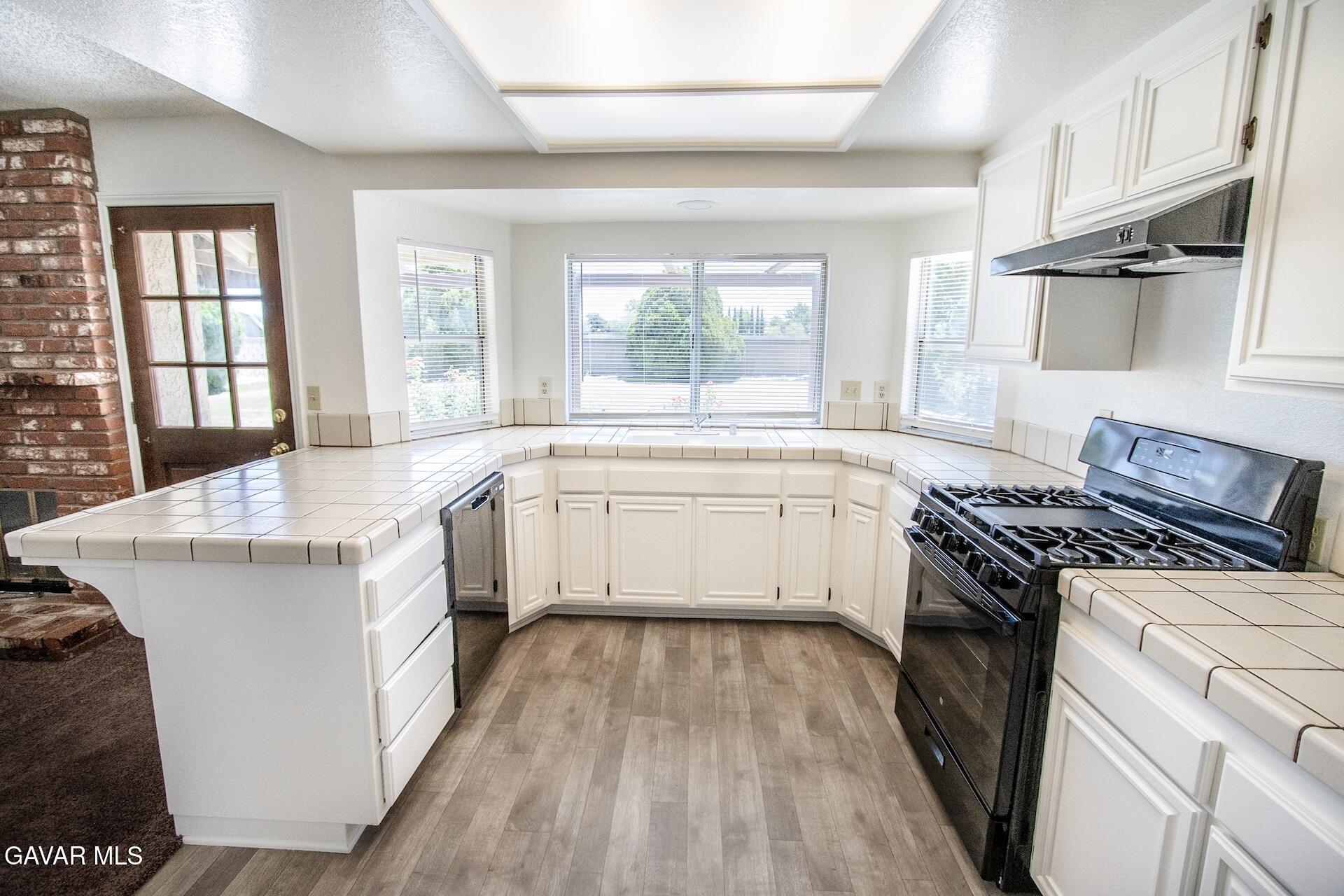 44318 33rd Street West Lancaster, CA 93536 - Photo 3 of 29 a kitchen with a stove a sink and a refrigerator