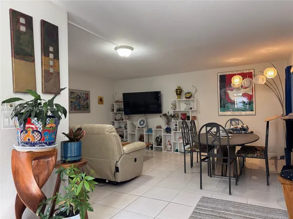 a living room with furniture a flat screen tv and a floor to ceiling window