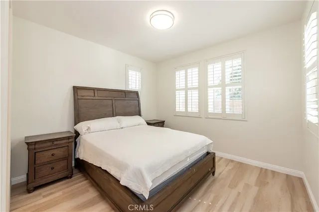 a bedroom with a bed and wooden floor