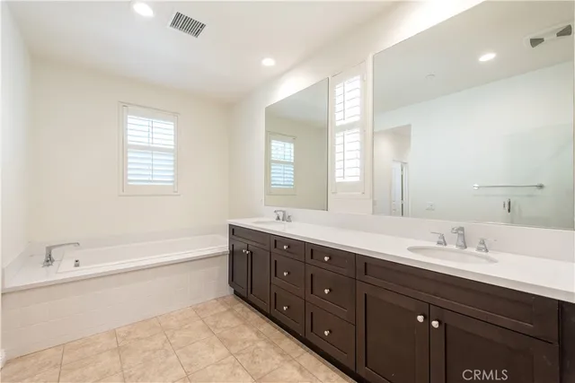 a bathroom with double vanity sink and a mirror