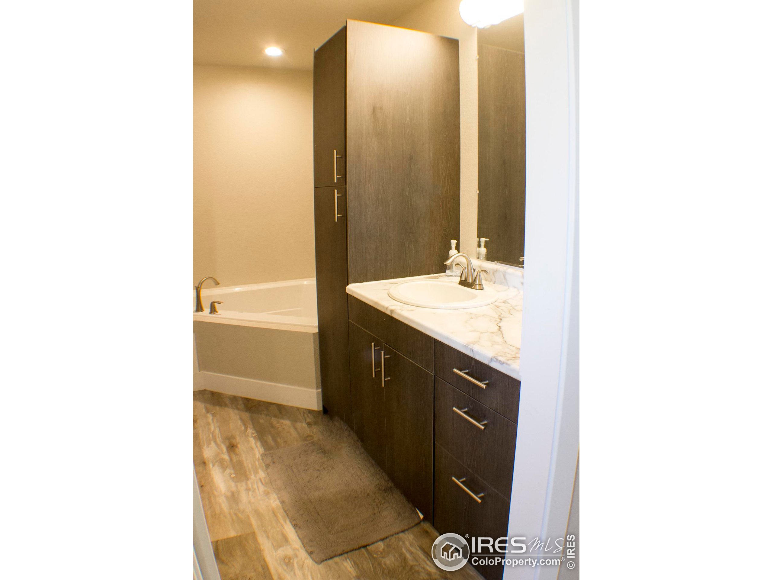 313 West Furry Street Holyoke, CO 80734 - Photo 11 of 23 a spacious bathroom with a double vanity sink a mirror and a bathtub