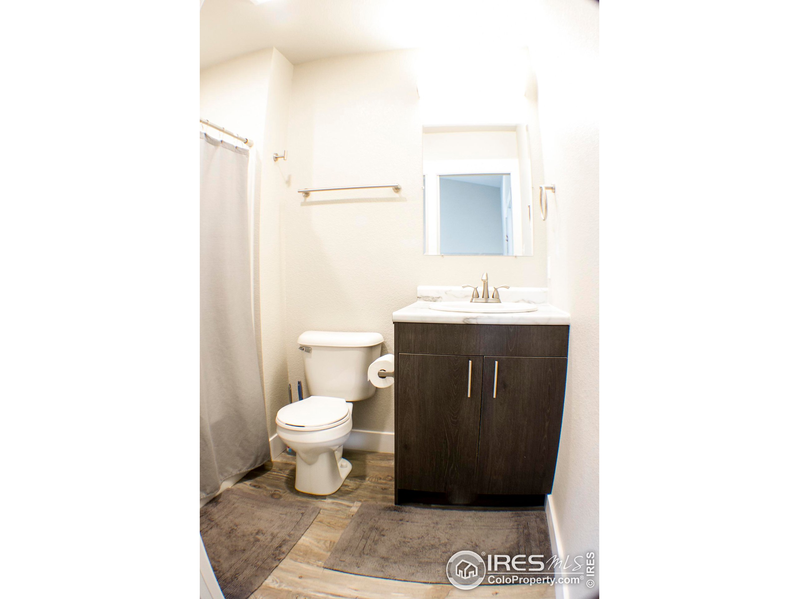 313 West Furry Street Holyoke, CO 80734 - Photo 18 of 23 a bathroom with a toilet sink and a mirror