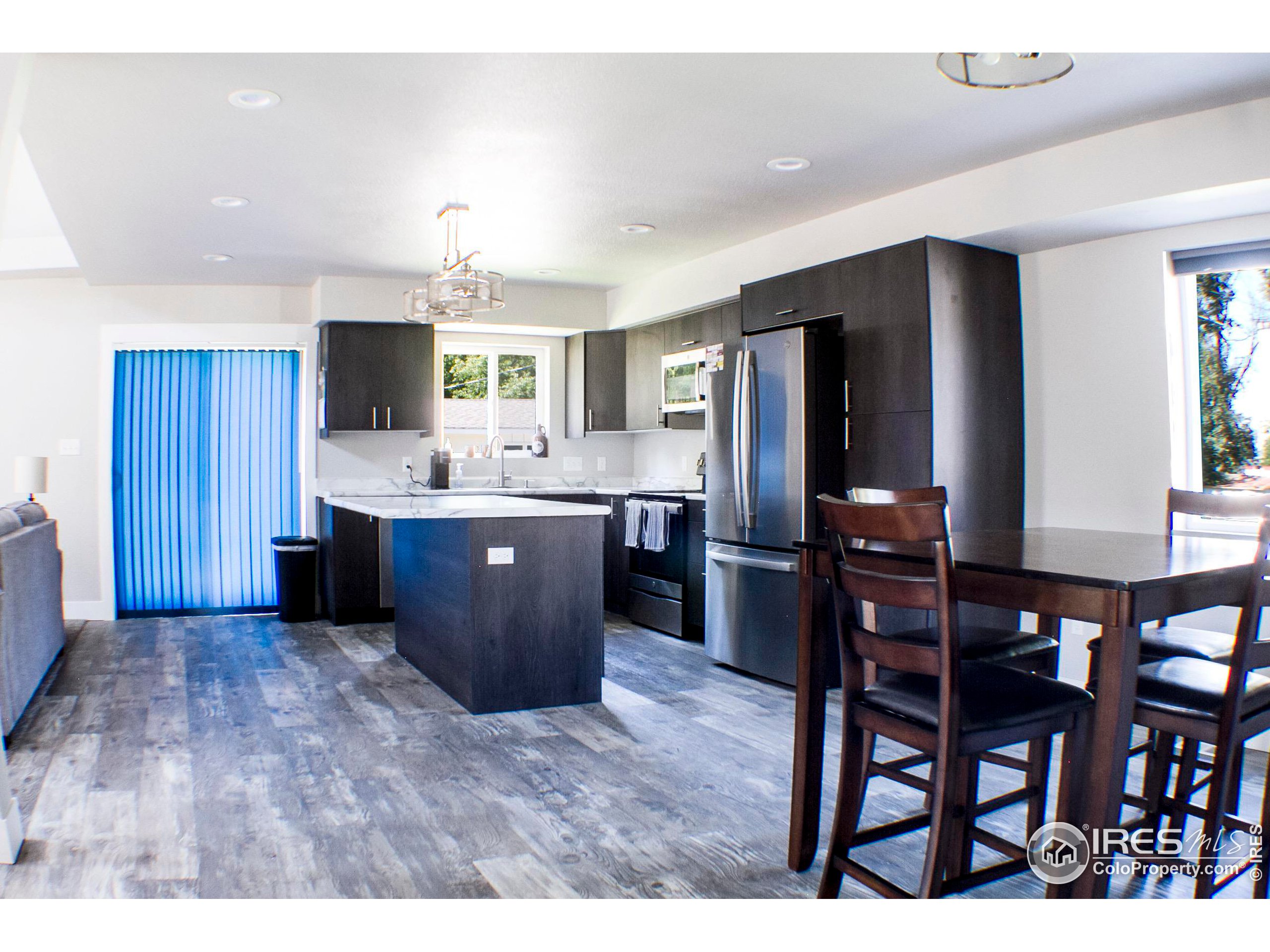 313 West Furry Street Holyoke, CO 80734 - Photo 6 of 23 a kitchen with stainless steel appliances kitchen island granite countertop a table chairs sink and cabinets