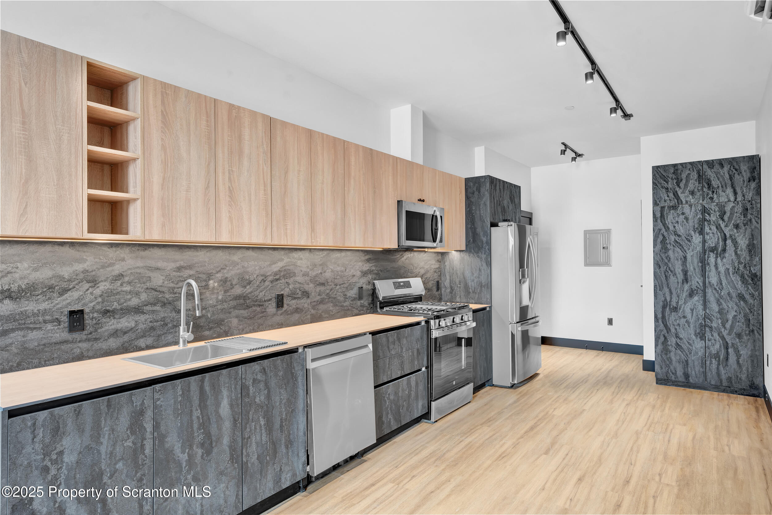 115 Penn Avenue, Unit 100 Scranton, PA 18503 - Photo 19 of 46 a kitchen with stainless steel appliances granite countertop a refrigerator a sink dishwasher a stove with wooden cabinets and floors