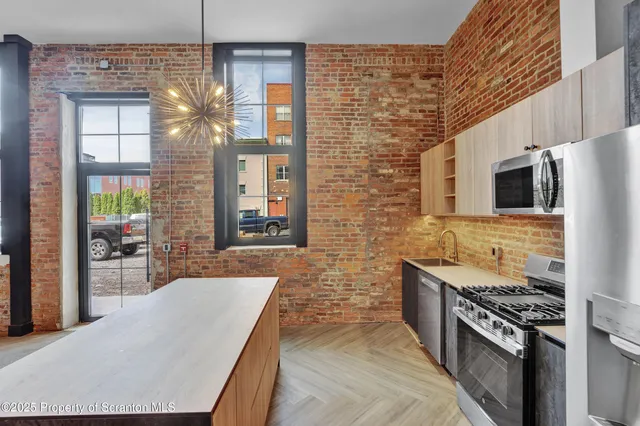 a kitchen with stainless steel appliances granite countertop a stove top oven a sink a counter space and cabinets