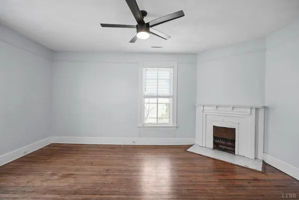 an empty room with wooden floor closet and windows