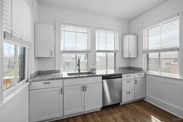 a view of empty room with wooden floor and window