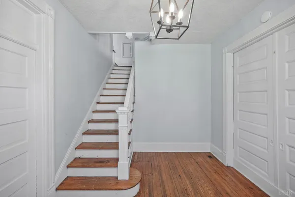 a view of empty room with wooden floor and entryway