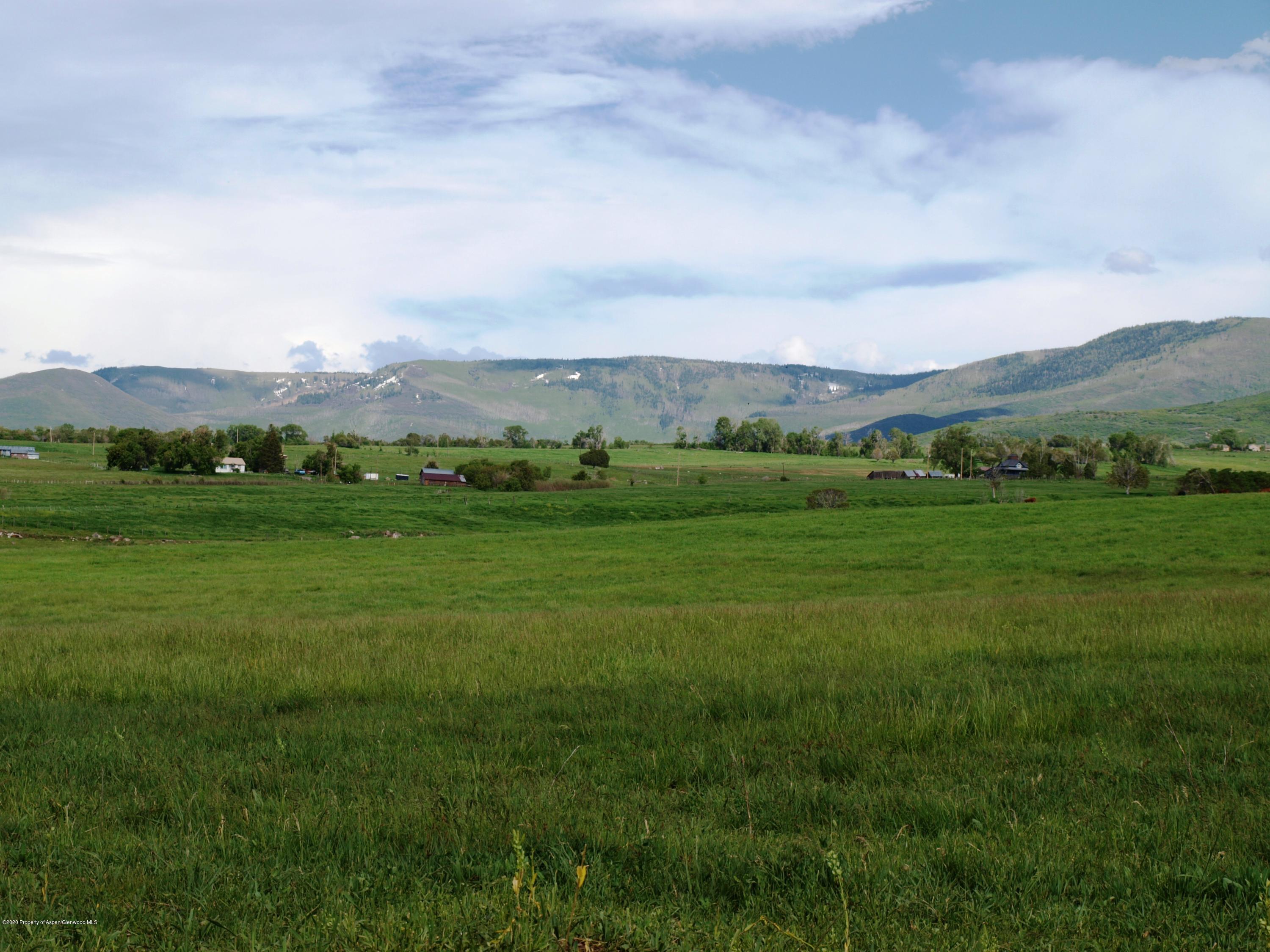 a view of grassy field with mountain