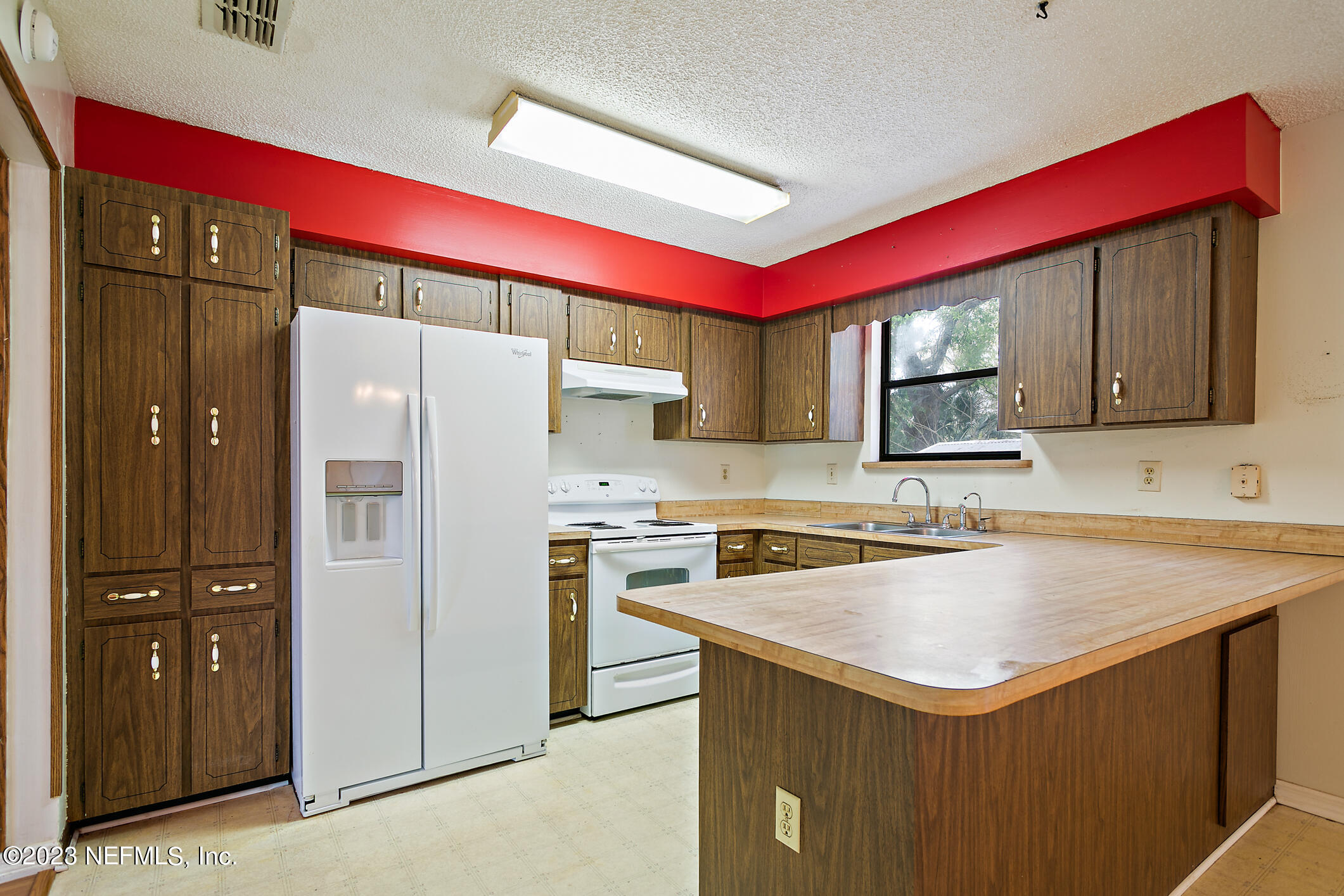 209 Jasmine Road St. Augustine, FL 32086 - Photo 8 of 35 a kitchen with a sink a refrigerator and cabinets