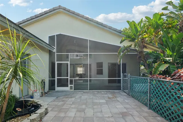 a view of a house with a yard and potted plants
