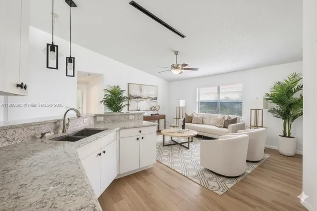 a living room with kitchen island furniture and a chandelier