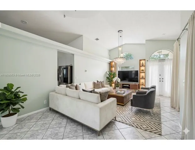a living room with furniture a fireplace and a potted plant