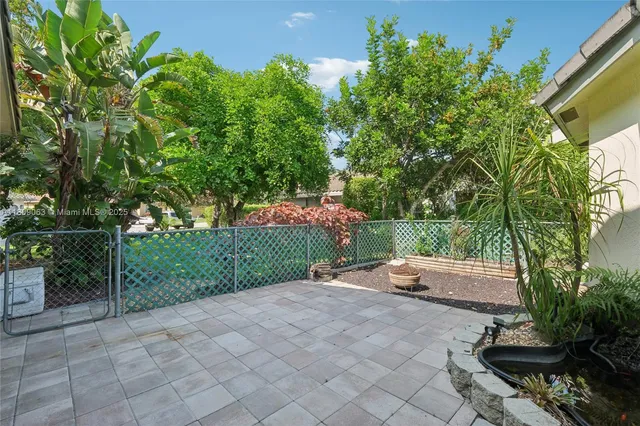 a view of backyard with table and chairs and potted plants