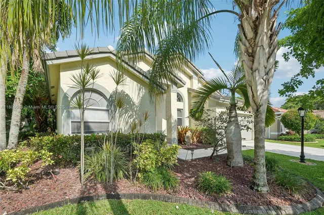 a view of a house with a yard and potted plants