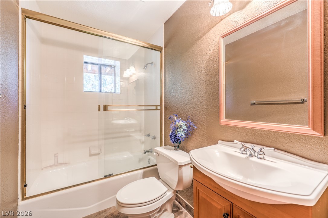 322 Ski Trail Road Mount Charleston, NV 89124 - Photo 29 of 58 Textured walls and a tiled tub shower frame this functional vanity area.