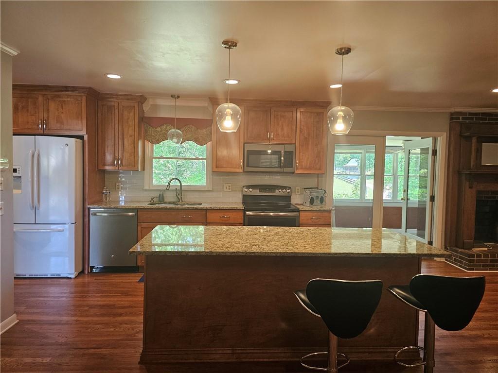 2107 Flat Shoals Road Southwest Conyers, GA 30094 - Photo 5 of 21 a kitchen with stainless steel appliances granite countertop a refrigerator a stove a sink dishwasher and a microwave with wooden floor