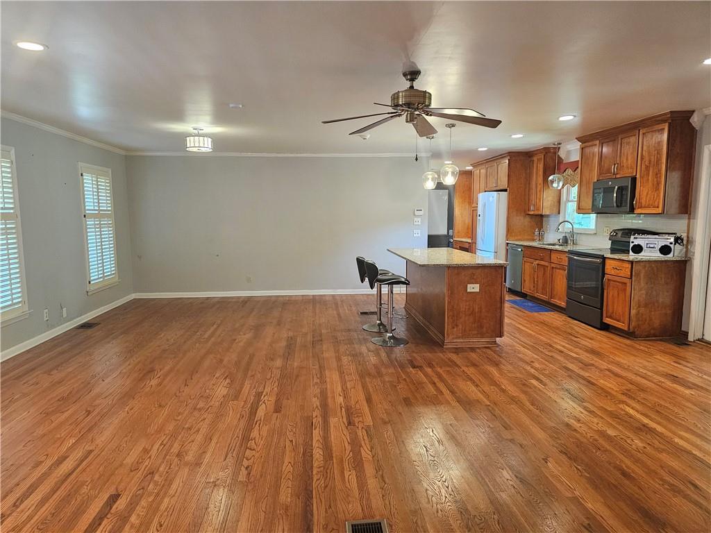 2107 Flat Shoals Road Southwest Conyers, GA 30094 - Photo 8 of 21 a room with wooden floors and kitchen view