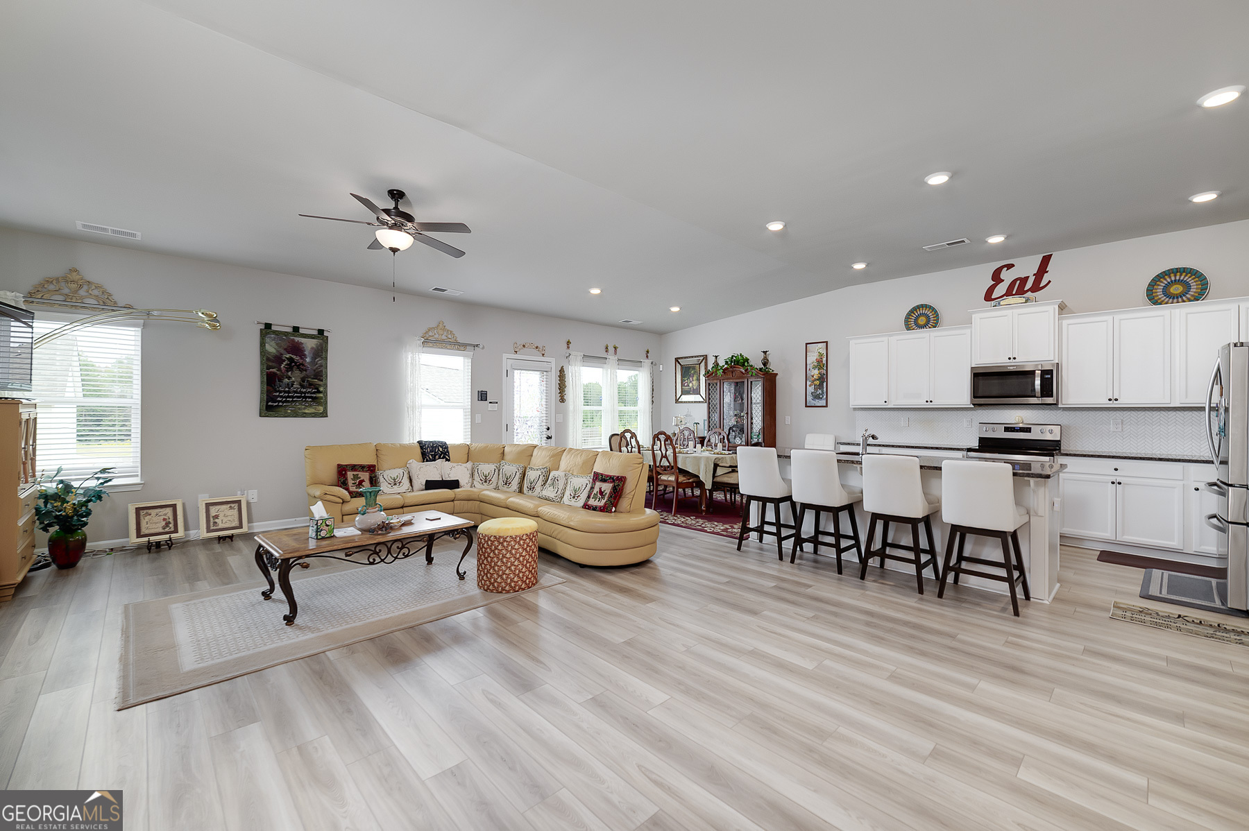 1517 Stinson Lane, Unit PHASE Locust Grove, GA 30248 - Photo 14 of 46 a living room with furniture kitchen view and a wooden floor