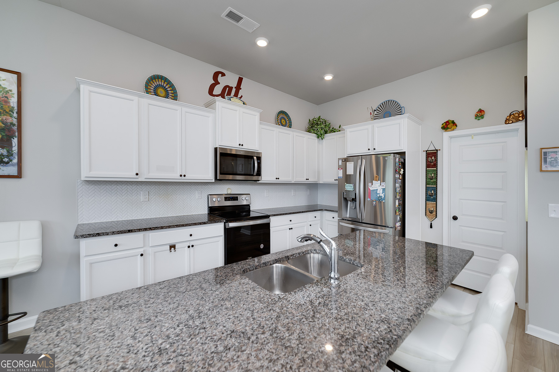 1517 Stinson Lane, Unit PHASE Locust Grove, GA 30248 - Photo 15 of 46 a kitchen with granite countertop a sink a stove and a wooden cabinets