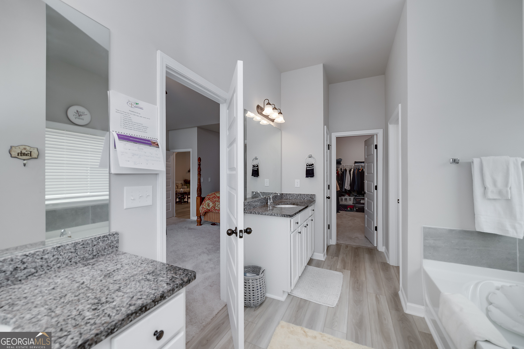 1517 Stinson Lane, Unit PHASE Locust Grove, GA 30248 - Photo 32 of 46 a large bathroom with a granite countertop sink and a mirror