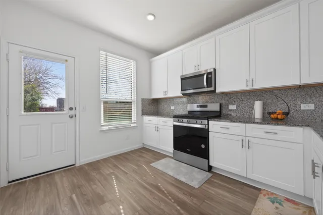 a kitchen with granite countertop white cabinets and white appliances