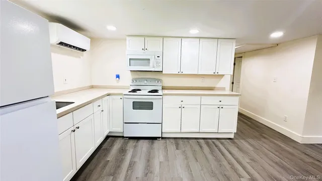 a kitchen with white cabinets sink and white appliances