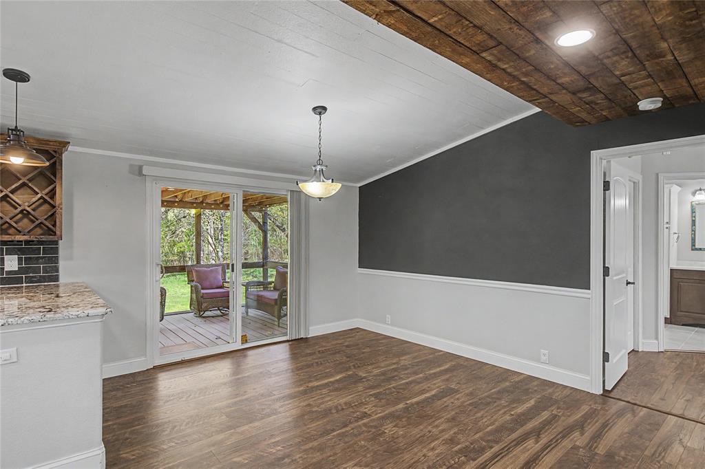 1701 Central Road Weatherford, TX 76088 - Photo 18 of 40 Breakfast nook or dining area featuring dark wood-style flooring, ornamental molding, shiplap ceiling, glass sliding door which leads to the covered back porch.