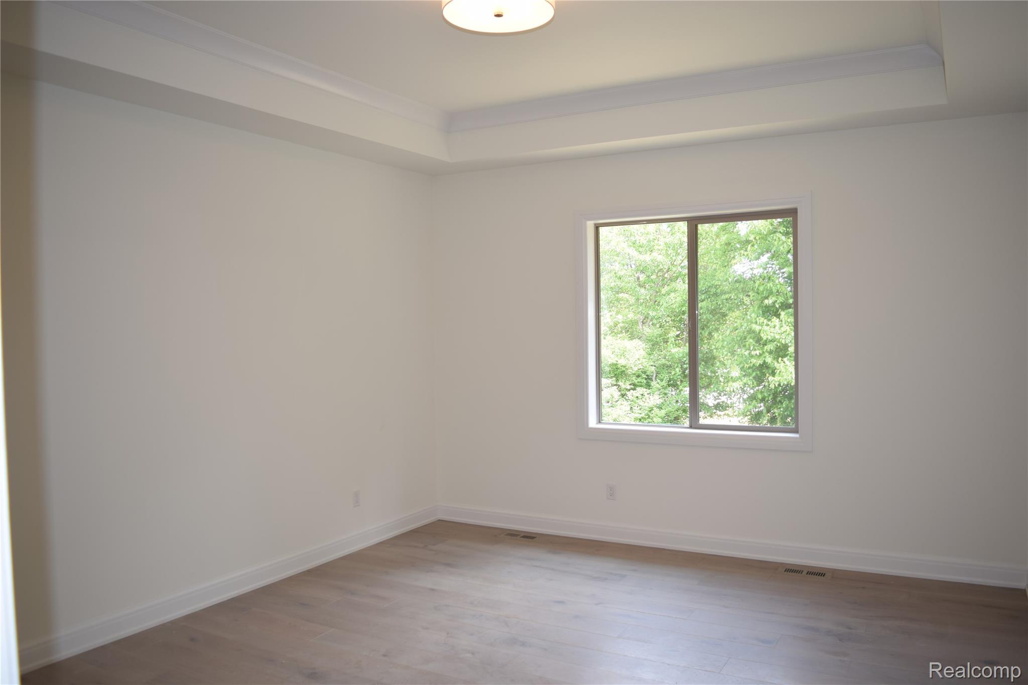 3093 Raffler Drive Rochester, MI 48307 - Photo 26 of 34 Unfurnished room featuring a tray ceiling and light wood finished floors