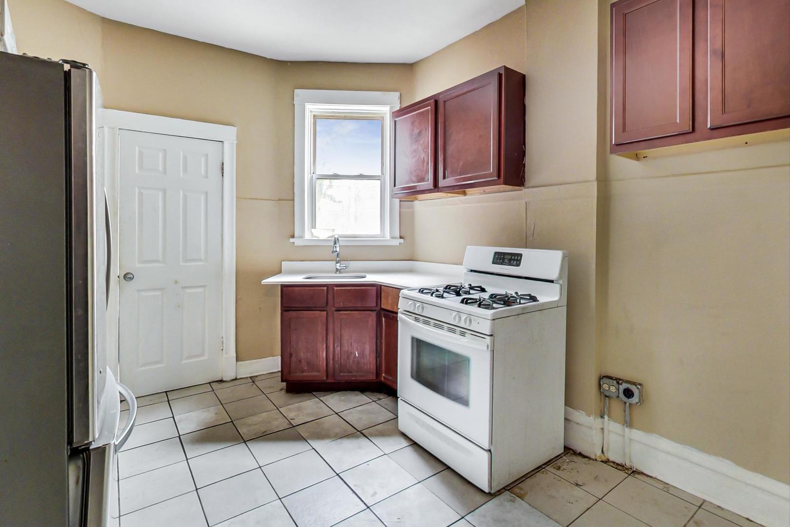 719 North Ridgeway Avenue Chicago, IL 60624 - Photo 14 of 58 a kitchen with granite countertop a stove a sink and a refrigerator