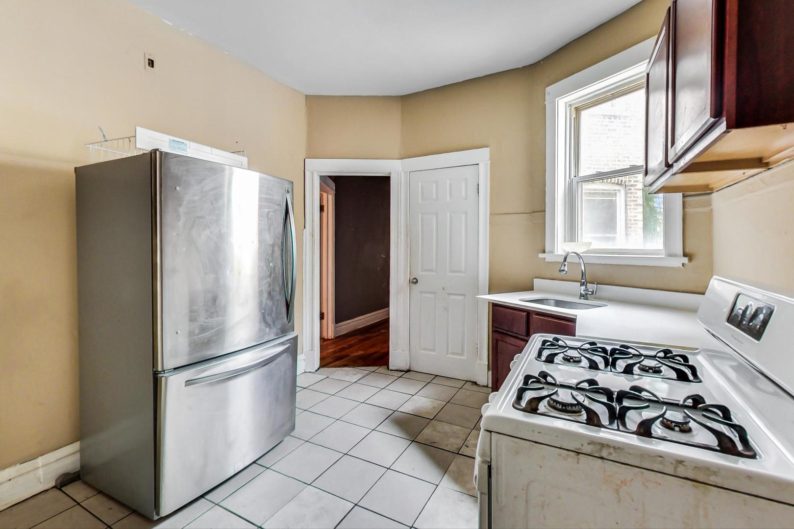 719 North Ridgeway Avenue Chicago, IL 60624 - Photo 15 of 58 a kitchen with stainless steel appliances granite countertop a refrigerator and a stove
