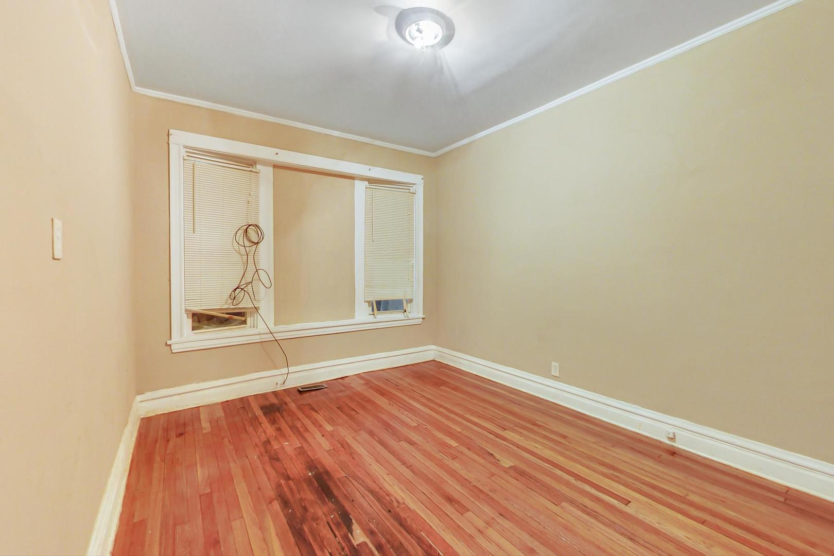 719 North Ridgeway Avenue Chicago, IL 60624 - Photo 17 of 58 an empty room with wooden floor and mirror